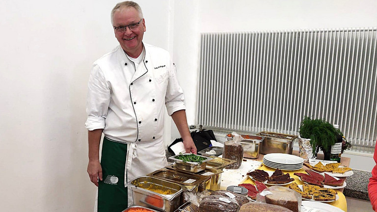 Lutz Fohgrub steht an einem Tisch mit Essen Lutz Fohgrub steht an einem Tisch mit Essen