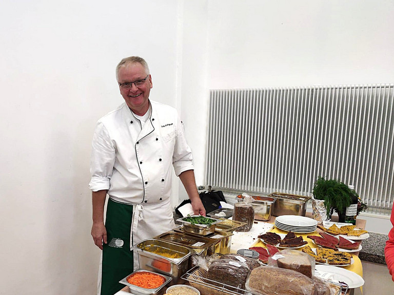 Lutz Fohgrub steht an einem Tisch mit Essen